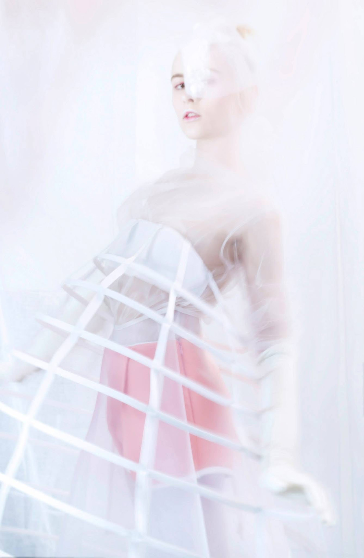 Ethereal fashion portrait in translucent pink and white.