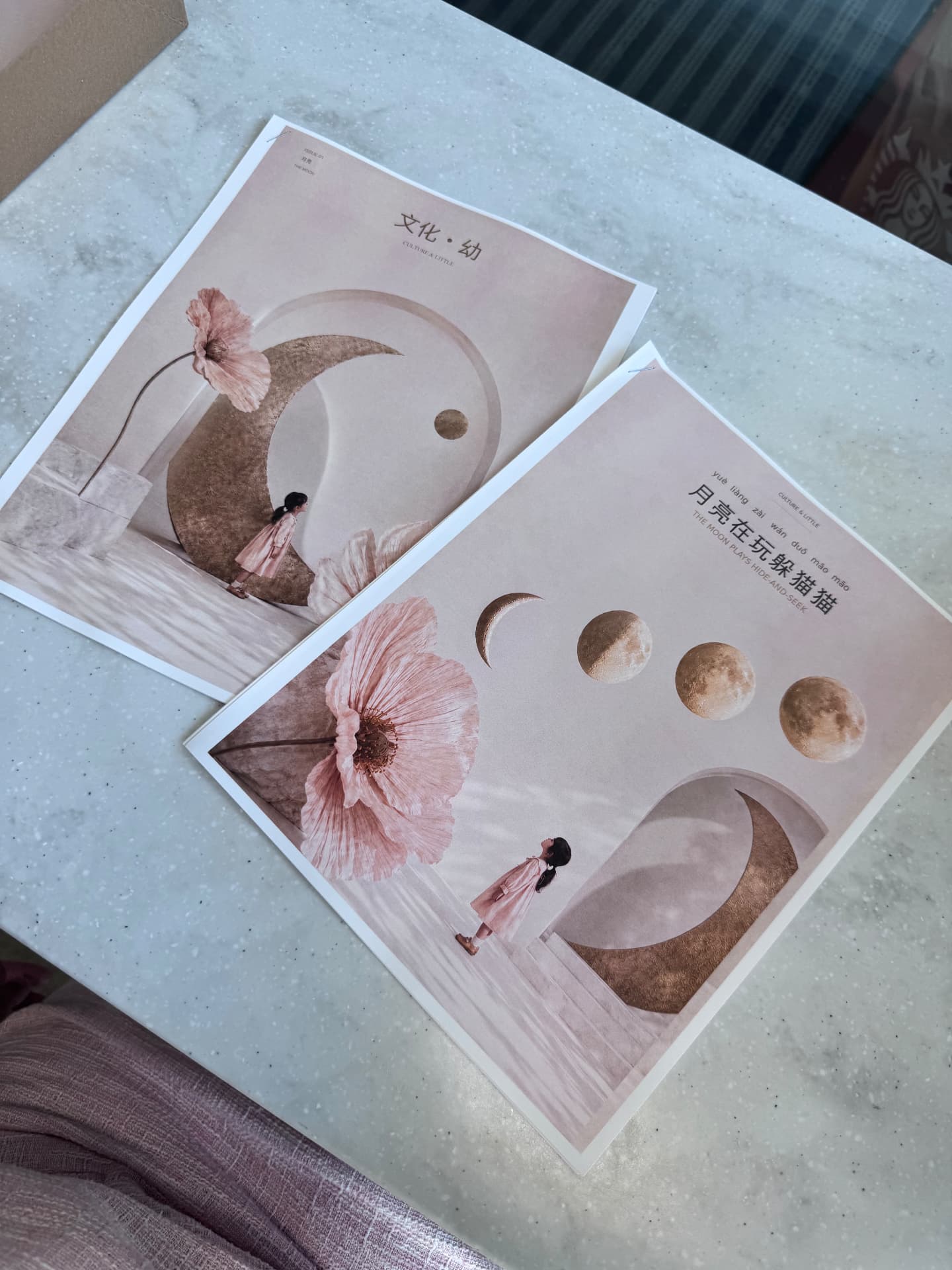 Culture & Little bilingual publication pages with moon phases and pink floral artwork on a tabletop.